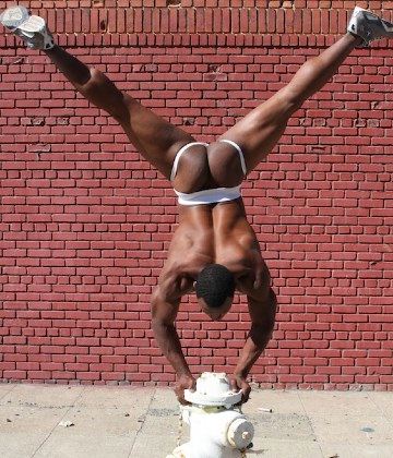 Young Black jock doing handstand in a jockstrap