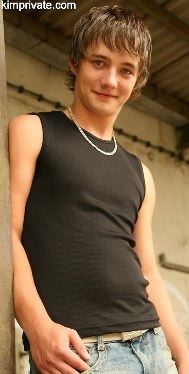 Boyish twink outdoors in a muscle shirt and jeans