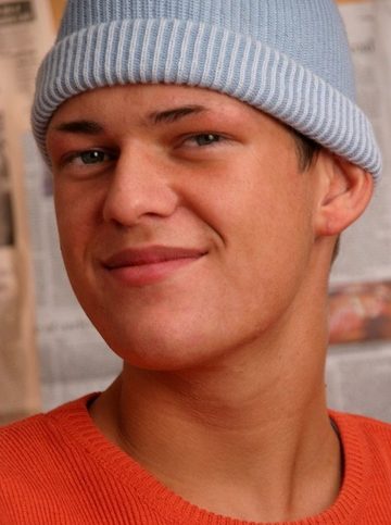 Young guy in a pale blue hat and orange sweater