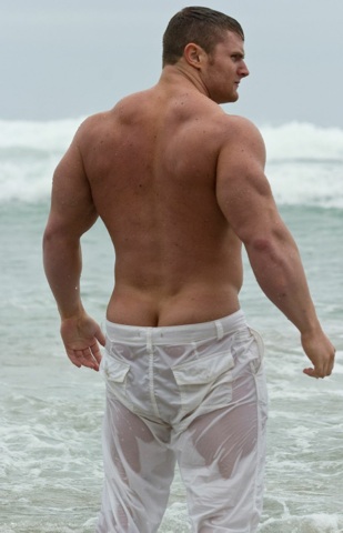 Muscle stud at the beach shows the top of his ass crack