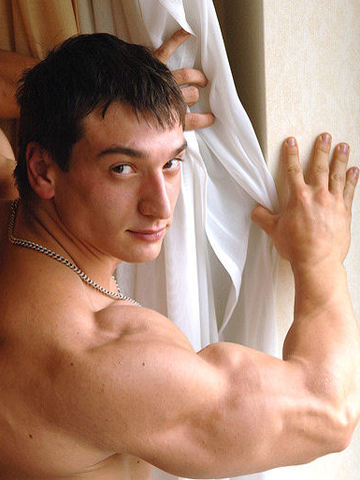 Cute young Russian bodybuilder flexing his shoulders