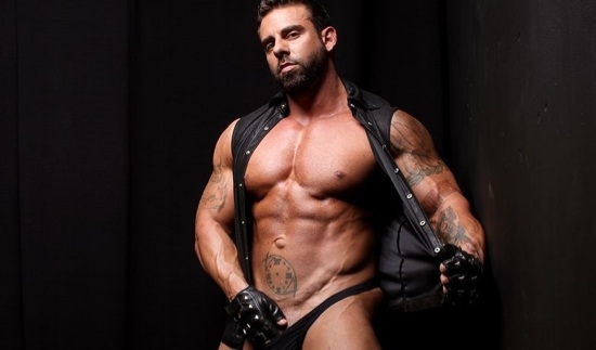 Xavier shows off his massive chest and inked arms