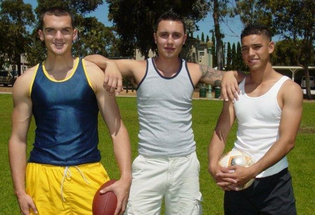 Three young college guys on a sports field