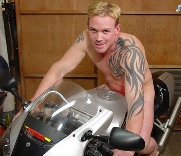 Tattooed blond stud on motorcycle