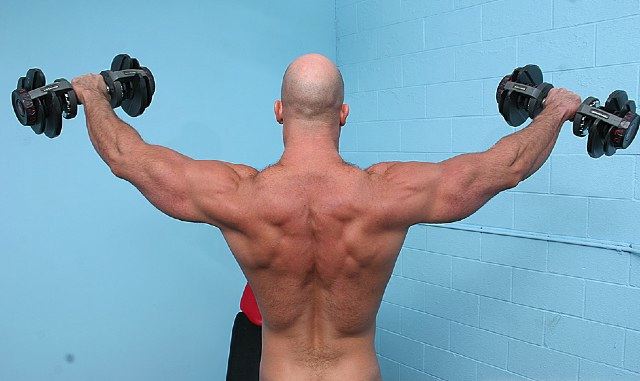 Bald muscle boy lifting weights