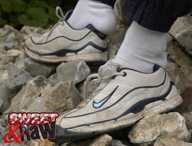 Close-up of twink\'s white sneakers with a blue swoosh