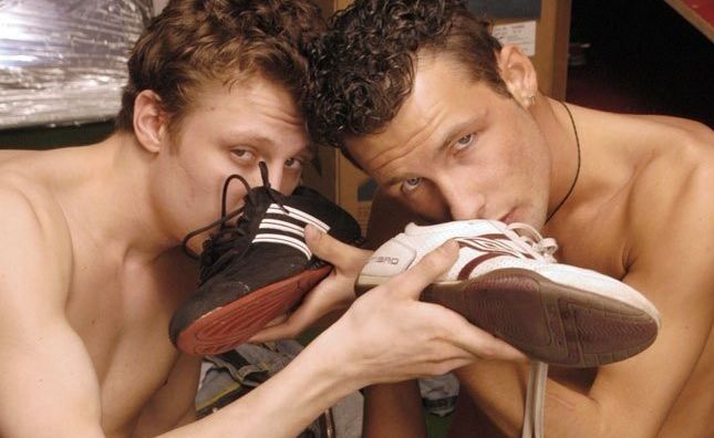 Curly haired jocks sniff their running shoes