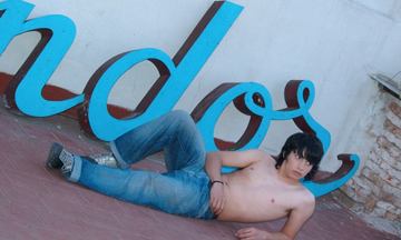 Shaggy shirtless twink laying outside