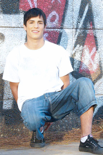 Young guy in front of graffiti wall